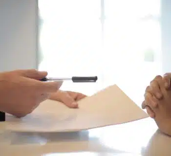 Crop businessman giving contract to woman to sign