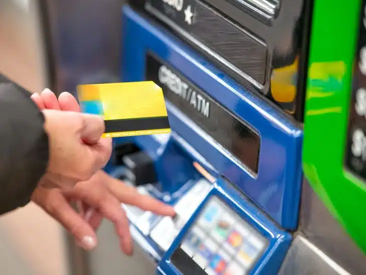 a person using a credit card to pay for a machine