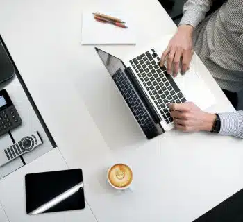 person using laptop on white wooden table