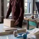 person holding cardboard box on table