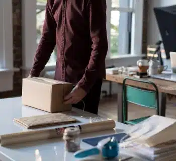 person holding cardboard box on table