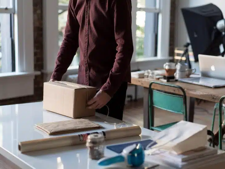 person holding cardboard box on table