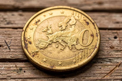 Gros plan sur une pièce rare de 50 centimes en euro posée sur une surface en bois brut, montrant les détails de frappe et la cote numismatique